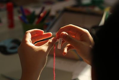 Mains d'un enfant travaillant un fil rouge lors d'un atelier